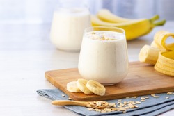 Vegan banana and oatmeal smoothie in glass jar on the light background. Healthy food.