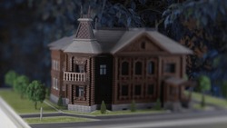 Close-up model of old house. Stock footage. Mock-up of old wooden manor house with garden. Light effect of changing days on small layout with house