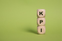 KPI, Key Performance Indicators acronym letters on wooden blocks isolated on light green background copy space