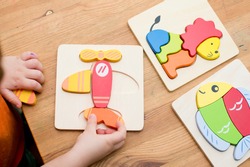  Jigsaw Baby Early Educational Toys 3D Puzzle Children Ability Exercise Kids Wooden Gifts. Boy hand on puzzle part. Early education, focus exercises