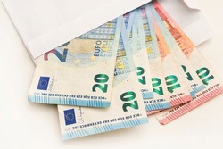 Bunch of Euro's. Close-up. Saving money. Keeping savings at home. Open envelope with Euro banknotes out from it. Finance, savings, investing. Money management at home. Financial business concept.
