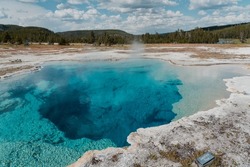 Sapphire pool, a large clear blue pool with a solid sinter rim level with the ground surface, shot in Yellowstone National Park, United States.