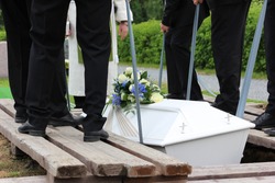 Pallbearers putting down the coffin at a funeral