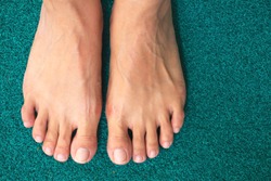 Top view barefoot on green background. Female feet. 