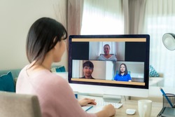 Asian business woman talking to her colleagues about plan in video conference. Multiethnic business team using computer for a online meeting in video call. Group of people smart working from home.
