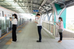 Three Asian people wearing mask standing distance of 1 meter from other people keep distance protect from COVID-19 viruses and people social distancing  for infection risk 