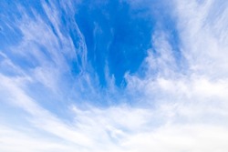 A vast blue sky with freedom shape of slanting clouds floating overhead. Soft and pure cloudy on a sunny day, calm and tranquil nature scene. Abstract background of natural cloudscape.