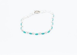 a metal bracelet made with mint green and clear stones inset in silver metal settings