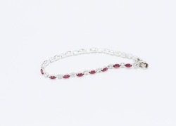 a metal bracelet made with pink and clear stones inset in silver metal settings