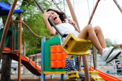 Smiling girl playing on a swing