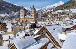 The center of Briancon with the famous Collegiale Church of Our Lady and Saint-Nicholas. Winter scene with snow covered rooftops. Hautes-Alpes (French Alps). France