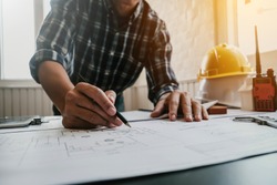 Male architect or engineer working at home drawing the construction project.