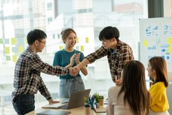 Happy young Asian business people shaking hands to congratulate success. Business executives handshake to congratulate the joint business agreement.
