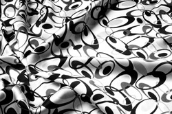 Texture background fabric silky white cloth with abstract black circles. which is important for stories about a dream. This design with a black background and contrasting floral and circular patterns