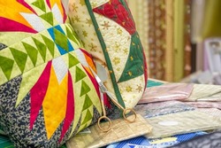 Patchwork style sofa cushions. needlework, in which small pieces of fabric of different patterns, colors or textures are sewn together.