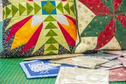 Patchwork style sofa cushions. needlework, in which small pieces of fabric of different patterns, colors or textures are sewn together.