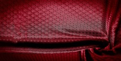 Red silk fabric with a fine checkered pattern. Background texture, pattern.