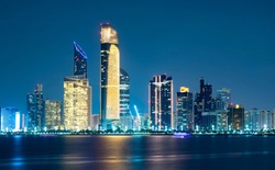 Beautiful City night view of Abu Dhabi financial and commercial district, taken during blue hour, view from marina backwater, United Arab Emirates, luxury life style, business in UAE, 