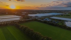 A bird's eye view. Aerial view of green fields with solar panels and netherlands at sunset. View from a flying drone. Top view