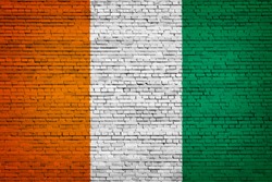 National flag of Cote d'Ivoire on a brick background