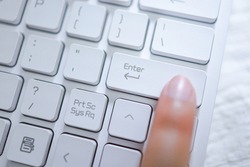 Hands of business woman Index finger pressing enter button on computer keyboard