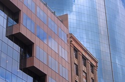 Abstract cityscape with three buildings. An old brick building along side two glass skyscrapers