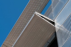 a metal facade of an office building covered with perforated steel sheets on a sunny day