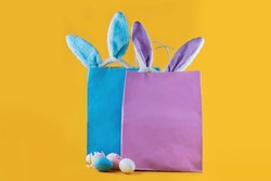 Very peri, blue shopping bag, rabbit ears and Easter eggs. Online shopping for the holidays. Symbols, traditions concept. Trending color of the year for Easter.