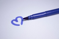 blue felt-tip pen with a painted heart next to it. stationery concept. copy space. isolated. High quality photo