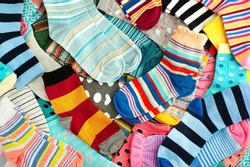 A bunch of colorful socks. Many different colorful socks for cold seasons. Clothing in the form of socks.
