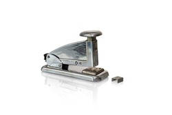 Vintage office stapler, pre 1964, pre 1964, with old-fashioned undulated rigged staples. Isolated on white background. Copy space.