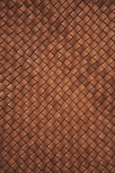 Vintage brown braided leather texture. Leather woven together. Abstract clothing background. Natural material. Vertical photo.