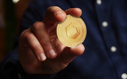 Chainlink link cryptocurrency symbol golden coin in hand abstract concept.