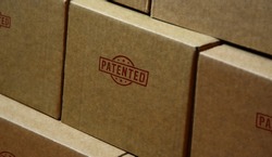 Patented stamp printed on cardboard box. Patent pending, reserved, copyright and protection of intellectual property concept.