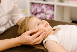 real doctor osteopath hands does physiological and emotional therapy for four year old kid girl. pediatric osteopathy treatment session. alternative medicine. taking care of the child's health
