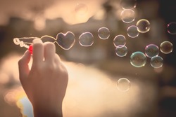  My Heart Bubbles at the sky, sunset,Love in the summer sun with bubble blower,romantic inflating colorful soap bubbles in park