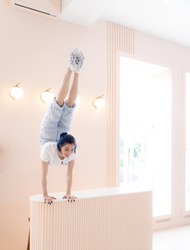 Flexible girl practice stretching and handstand at home. Concept of individuality, creativity and self-confidence