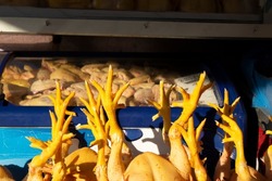 Food market in the Georgian city of Tbilisi. Store window with chicken feet. Concept of buying farm products for a restaurant in a street shop, a bird for dinner. Refrigerator with meat. Ingredient