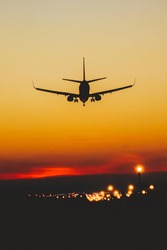 Airplane landing on the runway during sunset and night