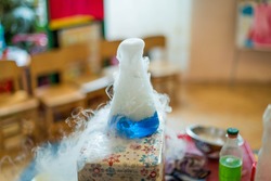 Experiments with dry ice for children. Smoke from the flask from reaction of dry ice with water, Chemical experience or experiment.