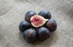 Group of whole figs in circle and one slice in the middle, sackcloth background, copy space, horizontal