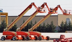 Three large work aerial platform lined up in an industrial site