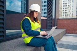 Industrial engineer woman using tablet computer at work on major construction site 