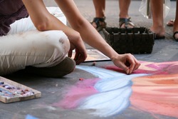 Summer. Italy. Florence. The artist paints a picture with chalk on the asphalt