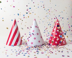 Colored confetti and party hat on white background. Minimal party concept.