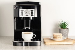 Modern espresso coffee machine with a cup in interior of kitchen closeup.