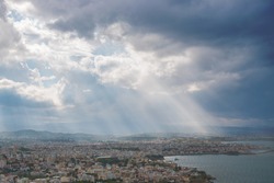 Sunbeams shining through the dramatic clouds over the city Chania. Greece. Crete.