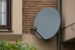 satellite dish antenna outdoor mounted at wall to recieve sat tv signal from outta space satellite