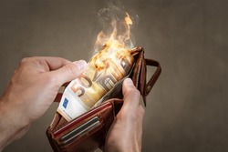A burning 50 Euro bill in a wallet