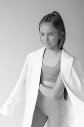 Stylish smiling fashionable young girl monochrome portrait in elegant suit and sport wear on white background.